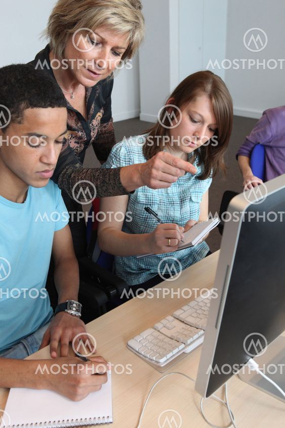 Teacher helping pupils with their assignment