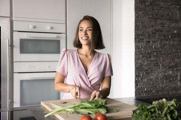 Woman prepares fresh vegetables on cutting board