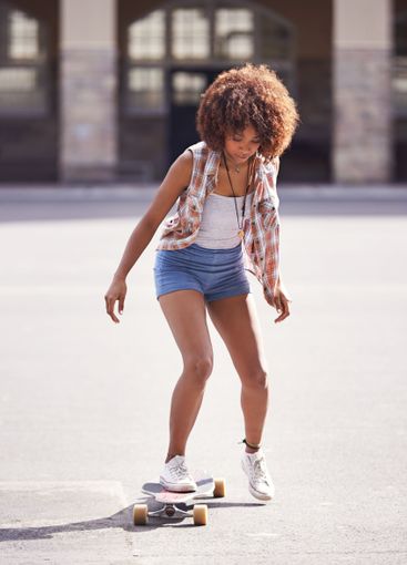 Woman, skateboard and ride at urban skatepark, sports...