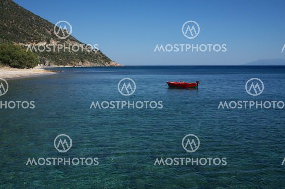 small red boat moored off greek coastline