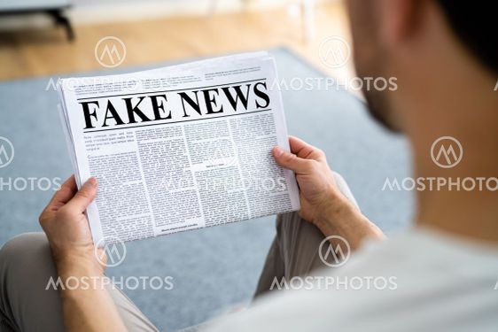 Businessman Reading Fake News Article On Newspaper