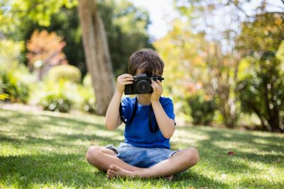 Young boy clicking a photograph from camera