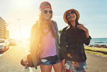 Walking, happy or women on road with skateboard for...