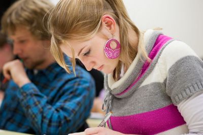 pretty, female college student sitting in a classroom...