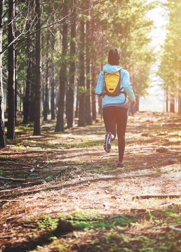 Exercise, running and woman in woods with wellness,...