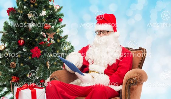 man in costume of santa claus with tablet pc