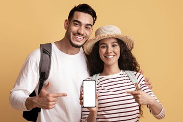 Cheerful Middle Eastern Travellers Couple Pointing At...