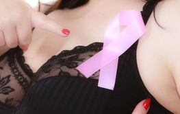 Big woman in bra with pink cancer ribbon
