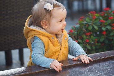 Pretty baby girl 1 year old playing in the yard outdoors