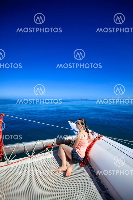 Young caucasian woman sitting in front of a boat