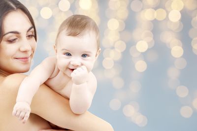 mother with baby over festive lights background