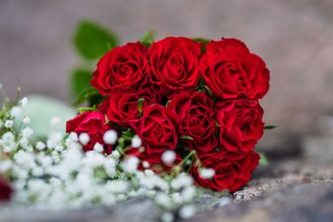 close-up of red rose bouquet on rustic stone.