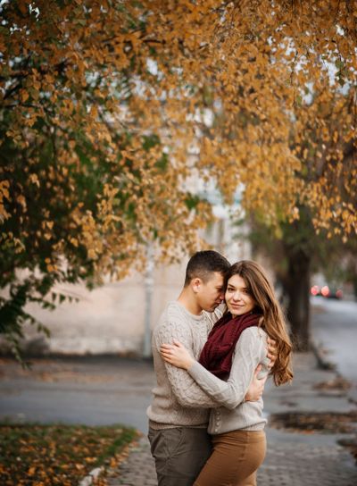 Young couple wearing on tied warm sweaters hugging in...