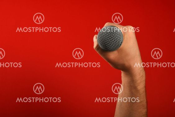 Man hand with microphone over red background