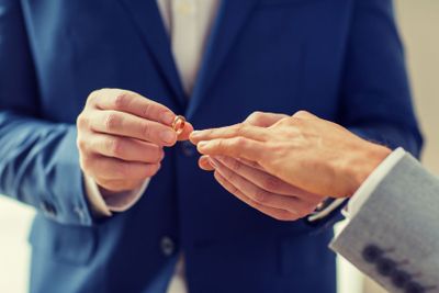 close up of male gay couple hands and wedding ring