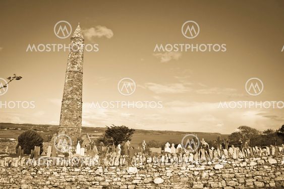 Ancient round tower and celtic graveyard in sepia