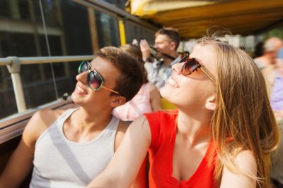 happy teenage couple traveling by tour bus