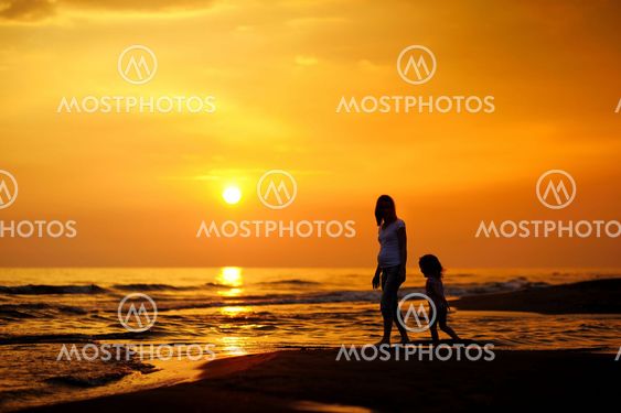 Pregnant mother and her child as silhouettes