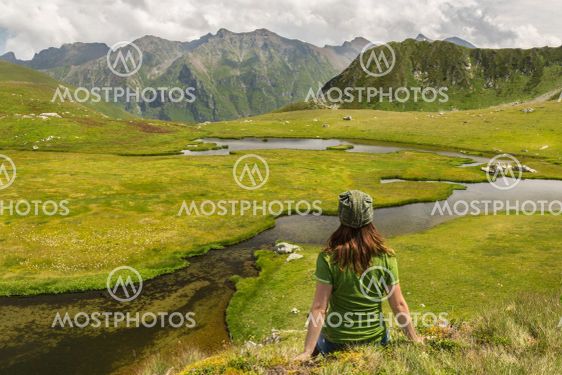 Young woman hiker enjoy the view on mountain peak cliff...