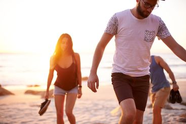 Friends, sunset and walk at ocean for journey, summer...