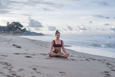 attractive young woman meditating in lotus pose...