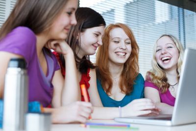 Four female college students working on their...