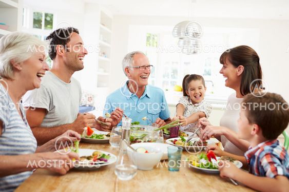 Multi Generation Family Eating Meal Around Kitchen Table