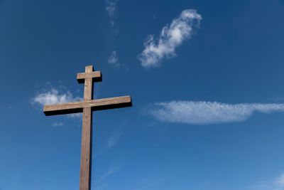 wooden christian cross on a blue sky background