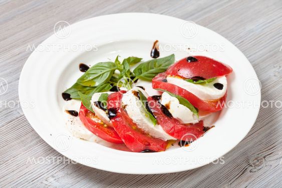 mozzarella cheese and tomato with basil leaves