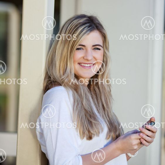 Girl Holding Mobile Phone In School
