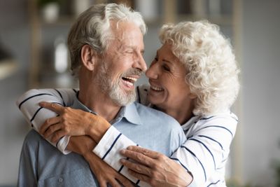 Happy elderly couple hug and cuddle sharing romantic moment