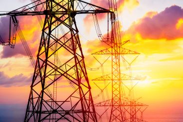 Electricity line on dusk orange sky, High voltage towers...