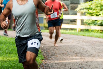 Runner racing in trail giving peace sign to photographer