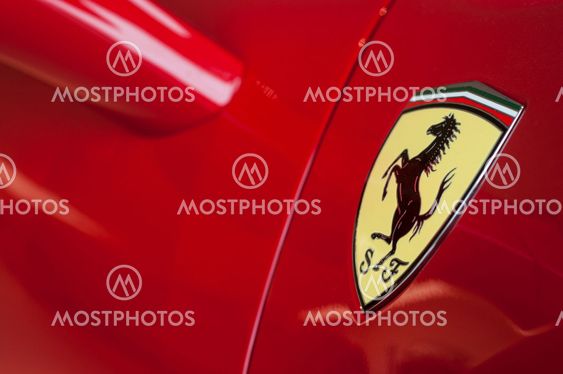 Ferrari logo on red sport car in ferrari retailer showroom