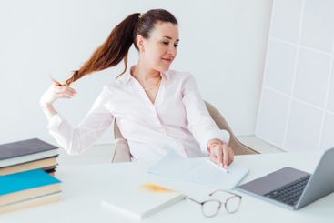 Brunette businesswoman sitting at desk in office with...