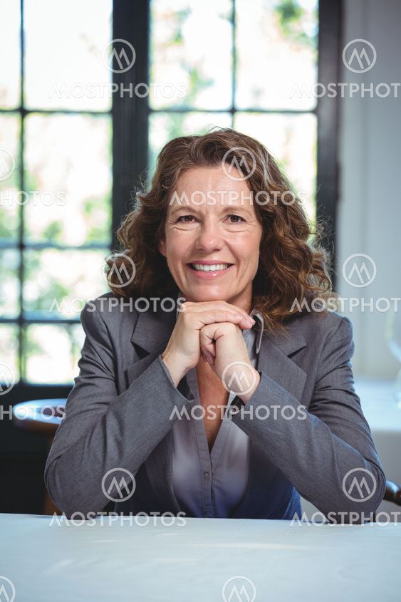 Smiling businesswoman leaning on a table