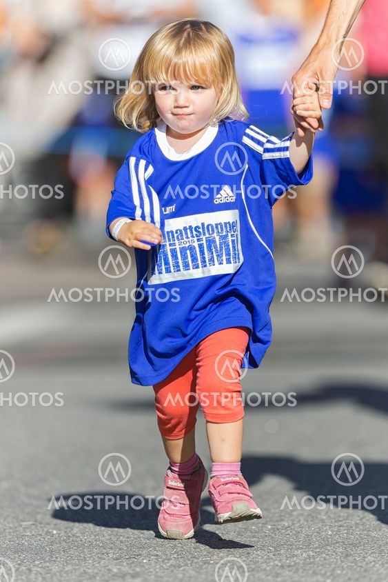 Small girl running hand in hand with father at the...