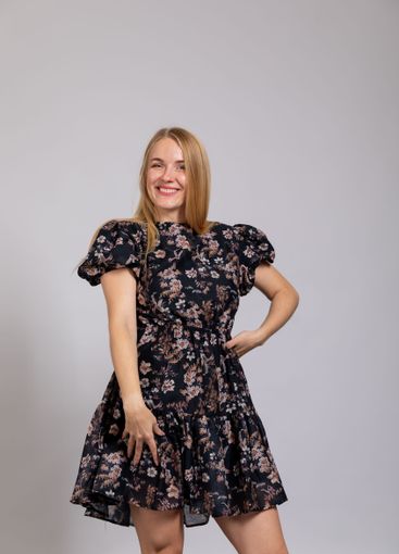 Beautiful blonde woman in summer dark dress on gray...