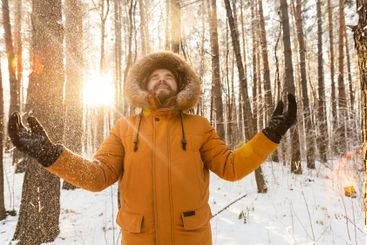 Man enjoying fresh snow in winter forest. Joy, freedom,...