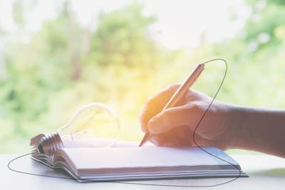 Close up hand writing on book paper with pencil...