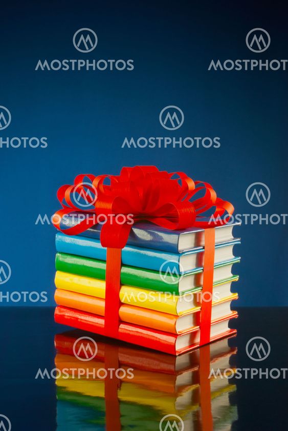 Stack of colorful books tied up with red ribbon