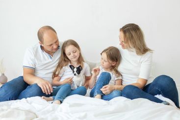 Lovely family relaxing on the bed together at home