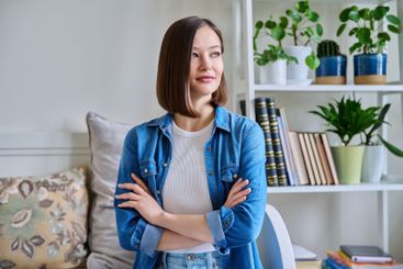 Portrait of young confident smiling woman in home interior
