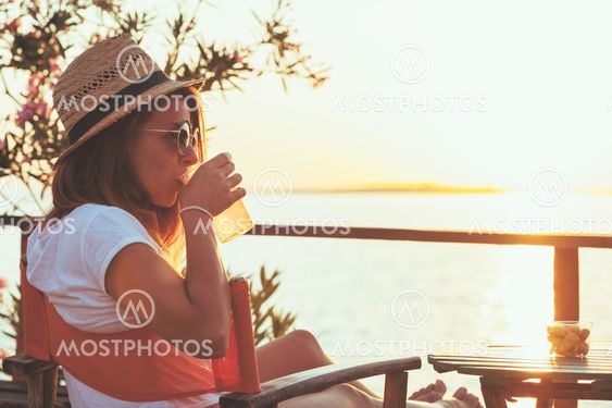 Young woman enjoying sunset at a beach bar
