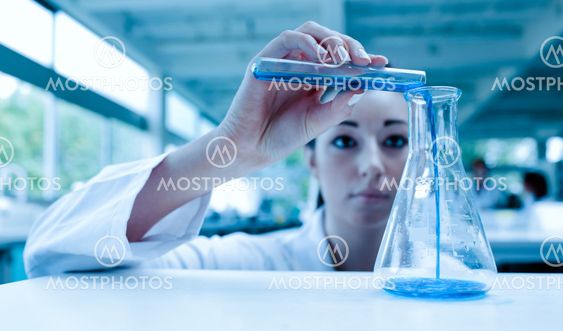 Scientist pouring a liquid in an Erlenmeyer flask with a test tube