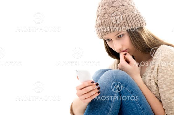 Upset teenage girl looking at her smartphone