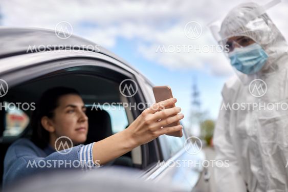woman in car showing phone to healthcare worker