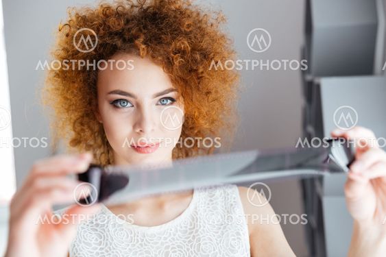 Beautiful woman photographer looking through photographic...