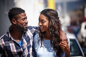Happy, black couple and walking together in city for...