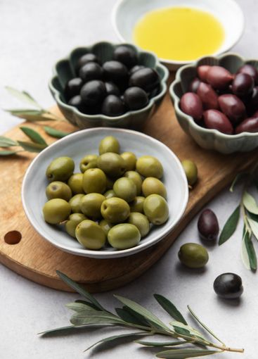 Variety of olives, olive oil, and olive branches served...